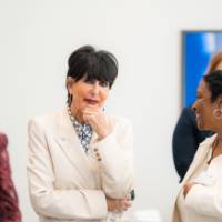 President Mantella with hand on chin, in conversation with event guest